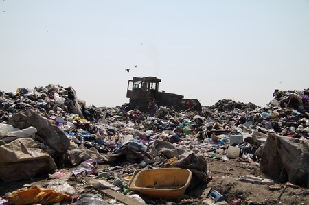 Бульдозер розрівнює і трамбує сміття